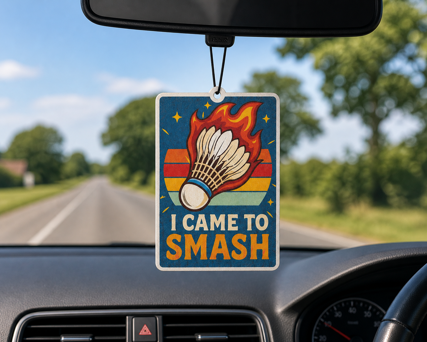 Car air freshener with a badminton design hanging from a car's rearview mirror.