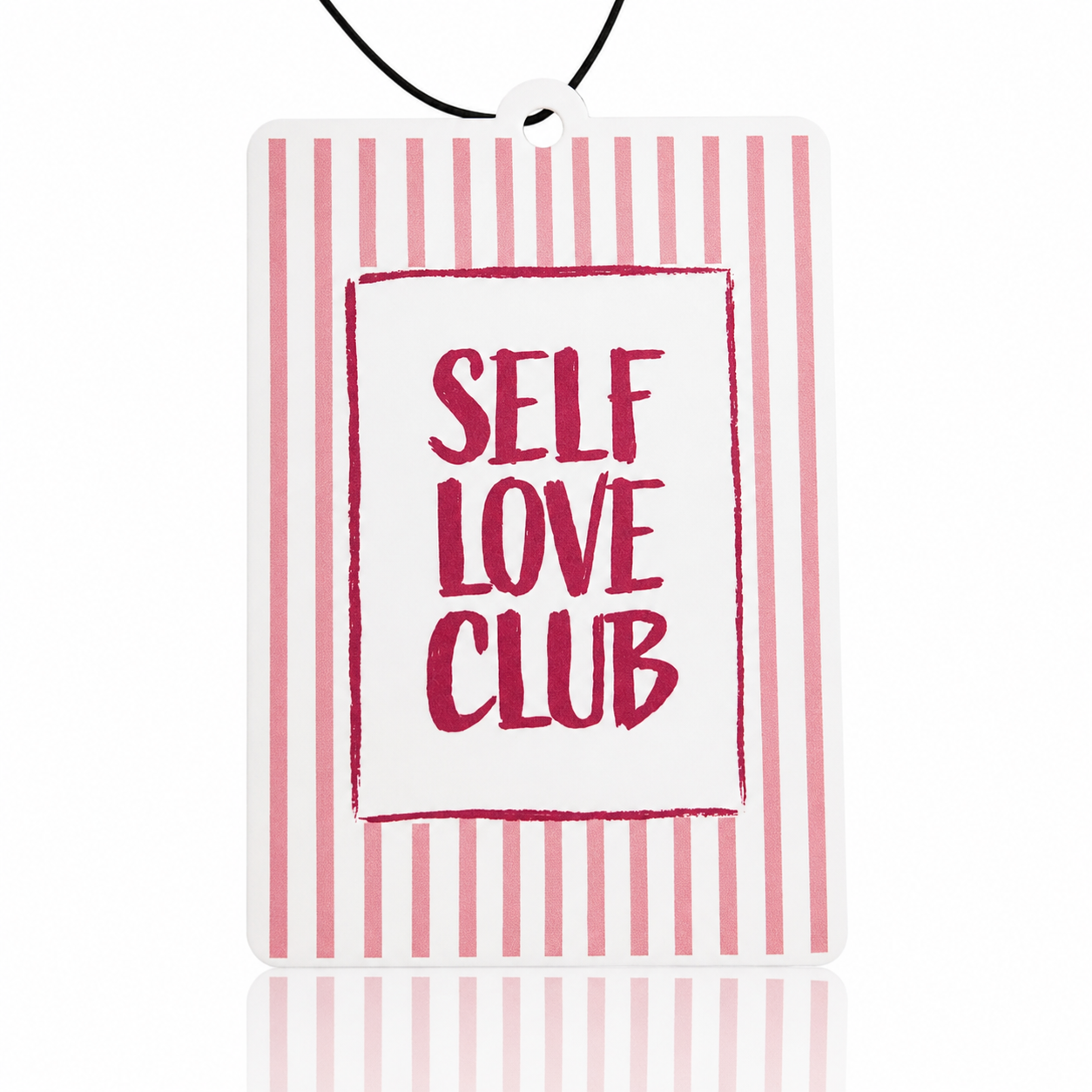 Car air freshener with 'Self Love Club' pendant on pink and white striped background
