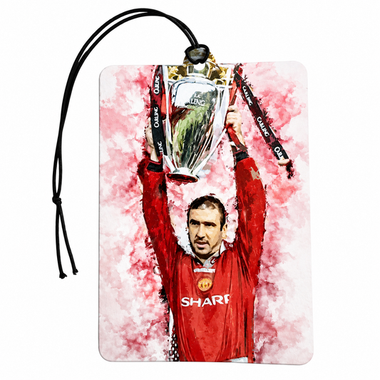 A rectangular luggage tag or car air freshener featuring a watercolor-style illustration of footballer Gary Lineker in a red Manchester United jersey holding a trophy, with a black hanging cord on a white background.