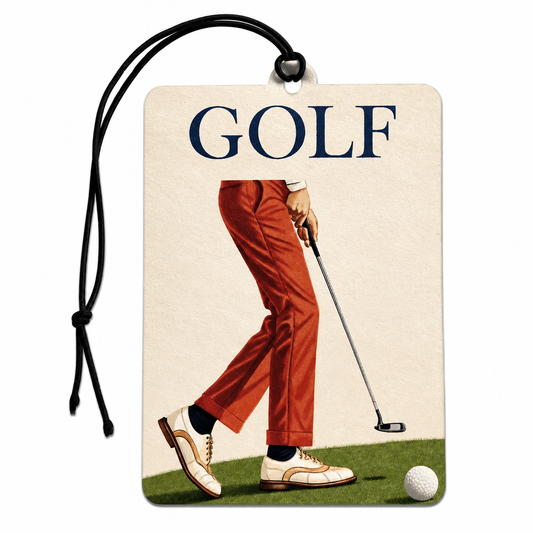 A rectangular luggage tag or car air freshener with a black hanging cord, featuring a vintage-style illustration of a golfer in rust-orange pants and white shoes on a golf green, with the word 'GOLF' printed at the top.