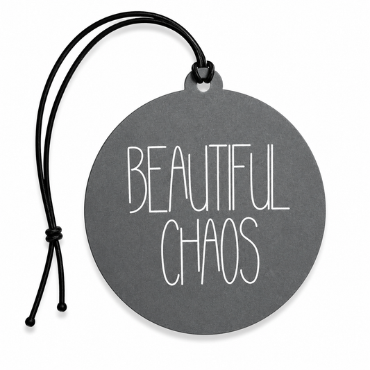 Grey round hanging air freshener featuring the words "Beautiful Chaos" in minimalist white lettering with a black hanging cord on a white background.