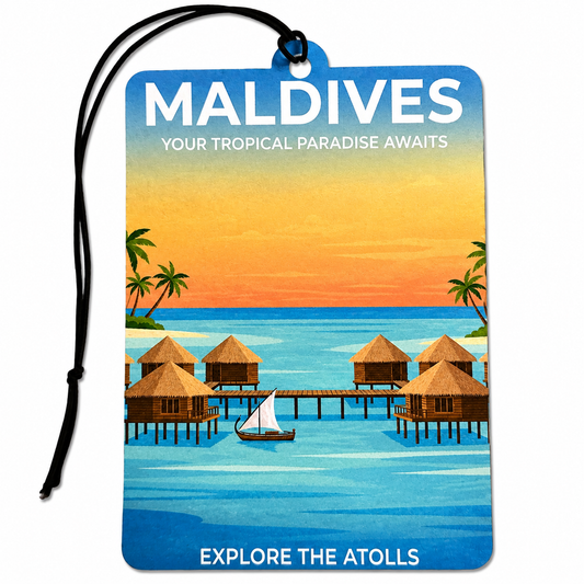 Maldives inspired car air freshener featuring tropical blue ocean water, overwater bungalows, palm trees, a sailing boat and a warm island sunset.