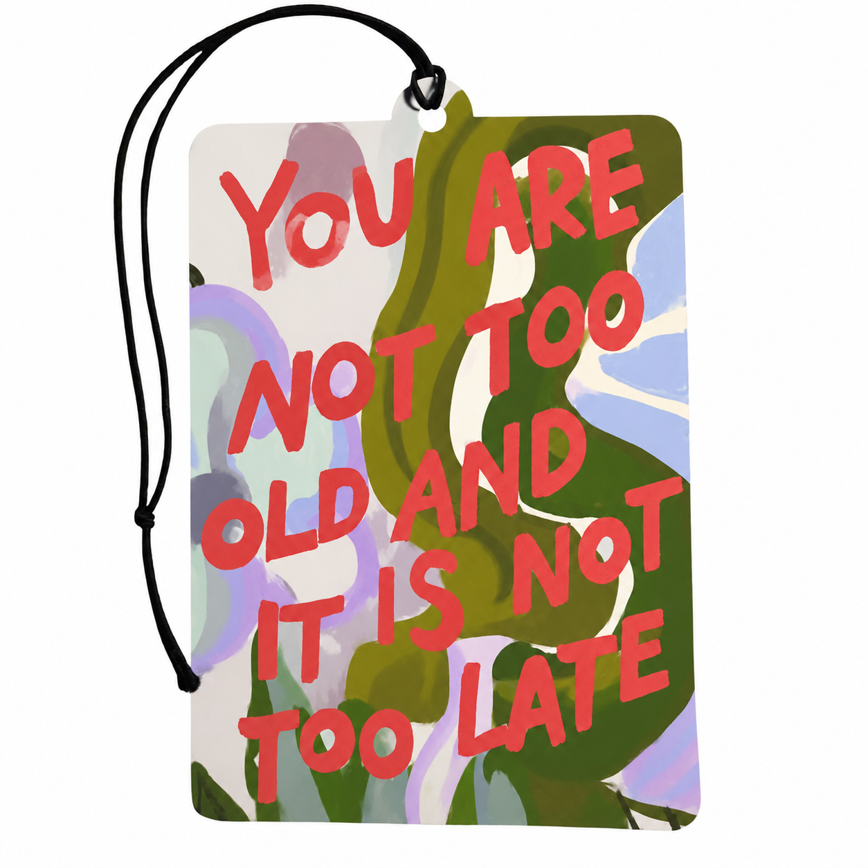 A rectangular car air freshener or tag with a black hanging cord, featuring a colorful abstract floral background and the motivational quote 'YOU ARE NOT TOO OLD AND IT IS NOT TOO LATE' in bold coral-red lettering.