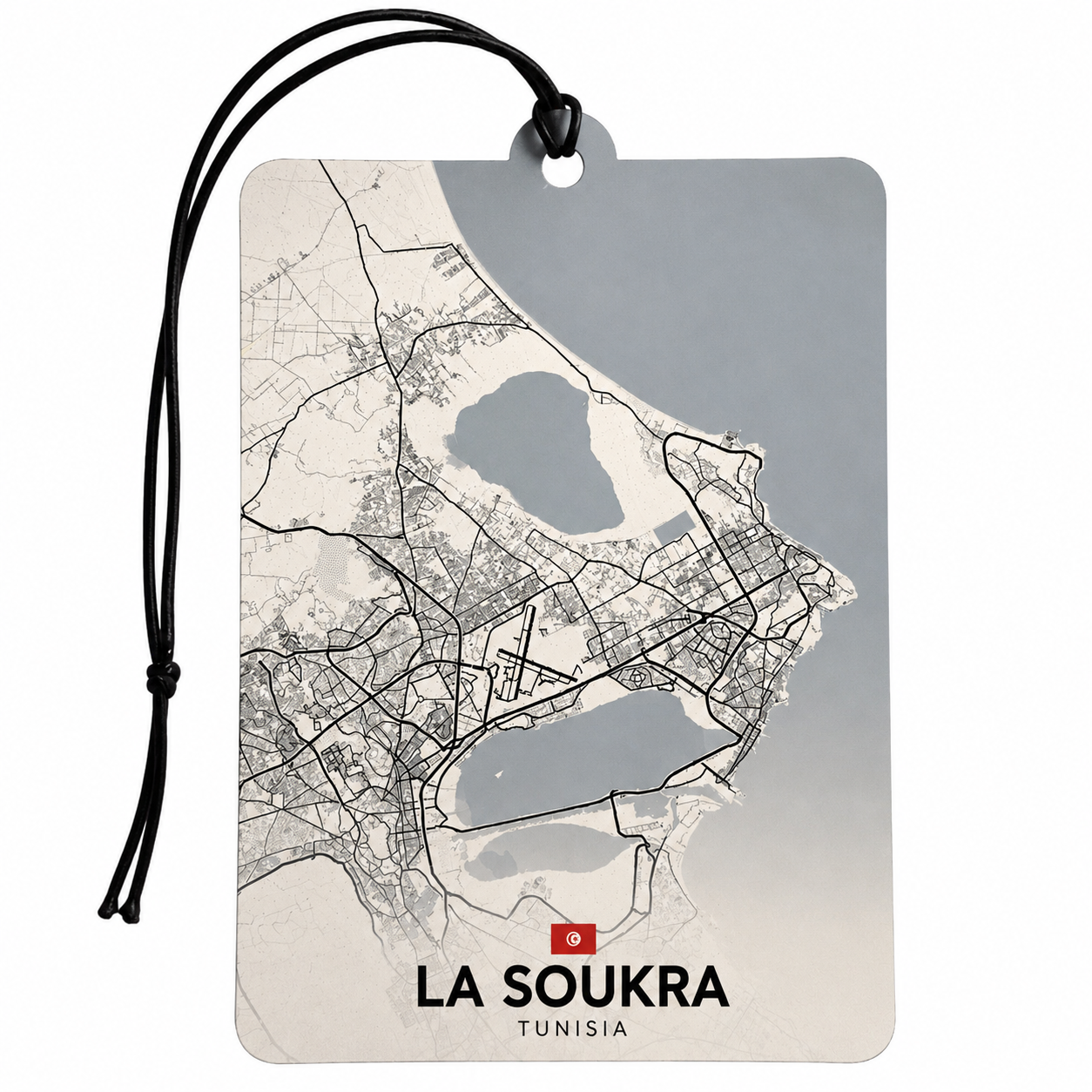 A rectangular luggage tag or car air freshener featuring a minimalist map of La Soukra, Tunisia, with a black hanging cord, set against a plain white background.