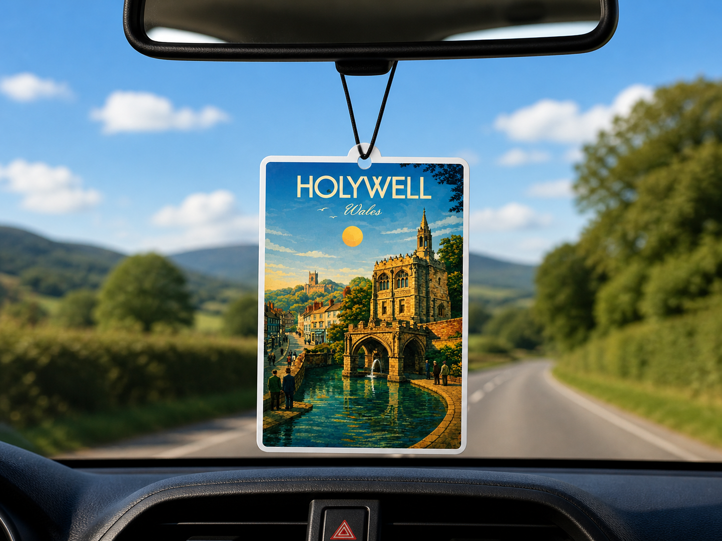 Car air freshener with a scenic view of Holywell, Wales hanging from a car's rearview mirror.
