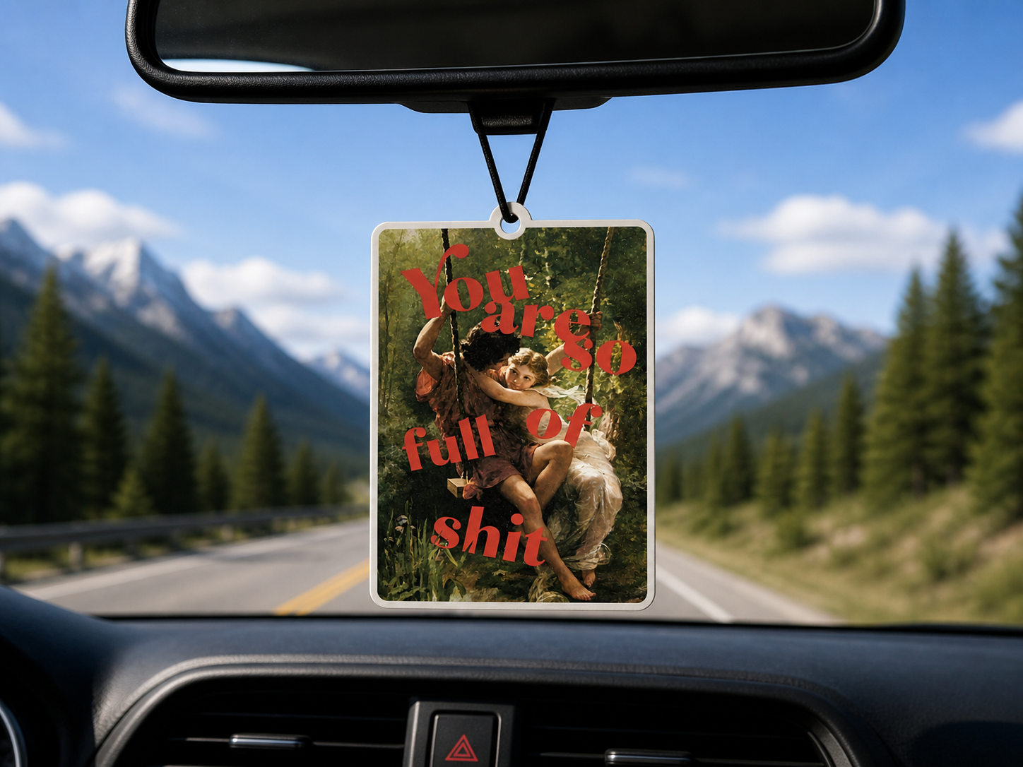 Car air freshener with a scenic background of mountains and trees, displayed in a car.