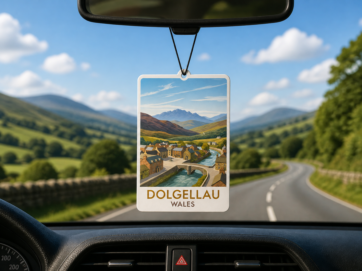 Car air freshener with a scenic view of Dolgellau, Wales hanging from a car's rearview mirror.