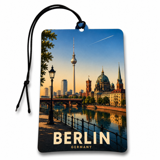 A rectangular car air freshener featuring a scenic print of the Berlin skyline, including the TV tower, dome, bridge, and river. The tag has a black hanging cord and the words 'BERLIN GERMANY' printed at the bottom.