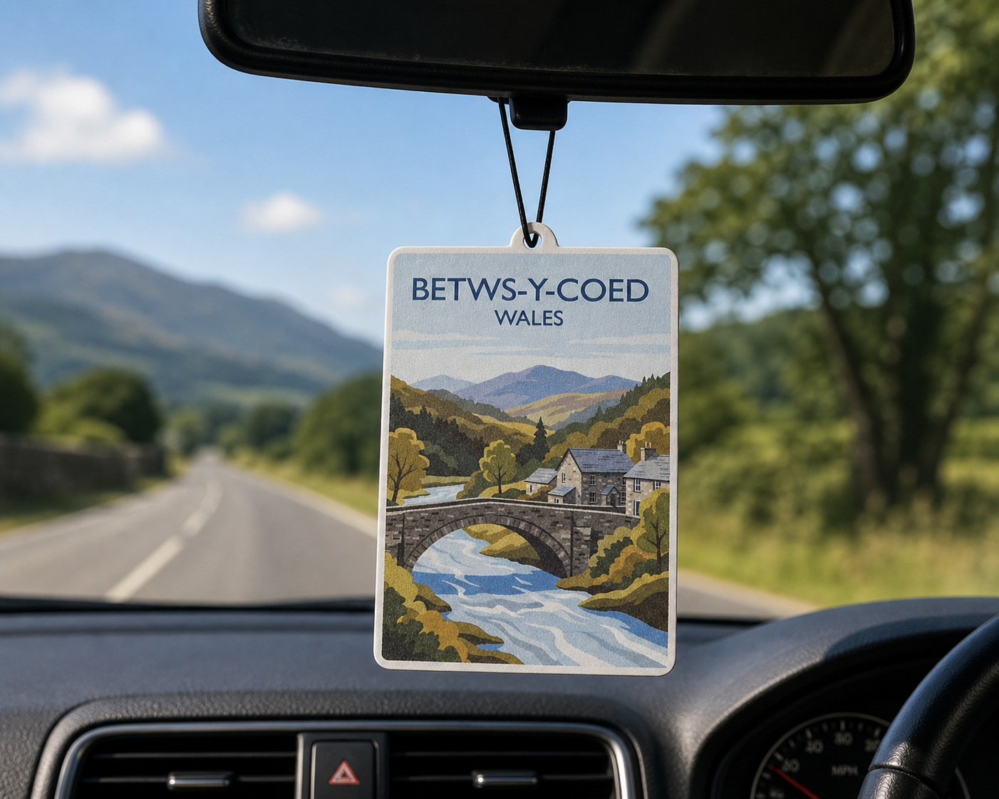 Car air freshener with a scenic design of Betws-y-Coed, Wales, hanging from a car's rearview mirror.