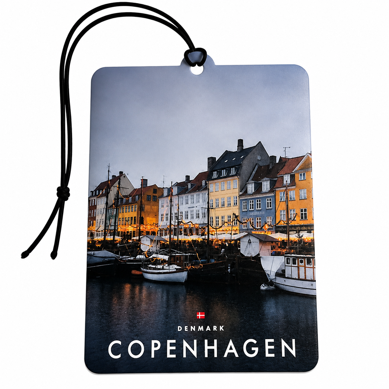 A rectangular hanging tag or car air freshener printed with a Copenhagen harbor scene, featuring colorful waterfront buildings, boats, and the text 'DENMARK COPENHAGEN' with a small Danish flag. A black cord is attached at the top, shown on a plain white background.