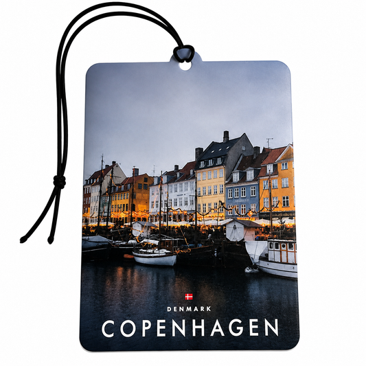 A rectangular hanging tag or car air freshener printed with a Copenhagen harbor scene, featuring colorful waterfront buildings, boats, and the text 'DENMARK COPENHAGEN' with a small Danish flag. A black cord is attached at the top, shown on a plain white background.