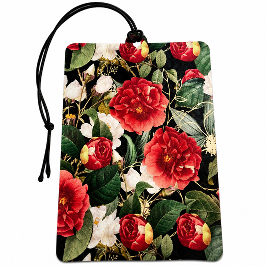A rectangular hanging card or car air freshener with a black cord loop at the top, printed with a dense floral pattern featuring large red and white flowers with green leaves on a black background.